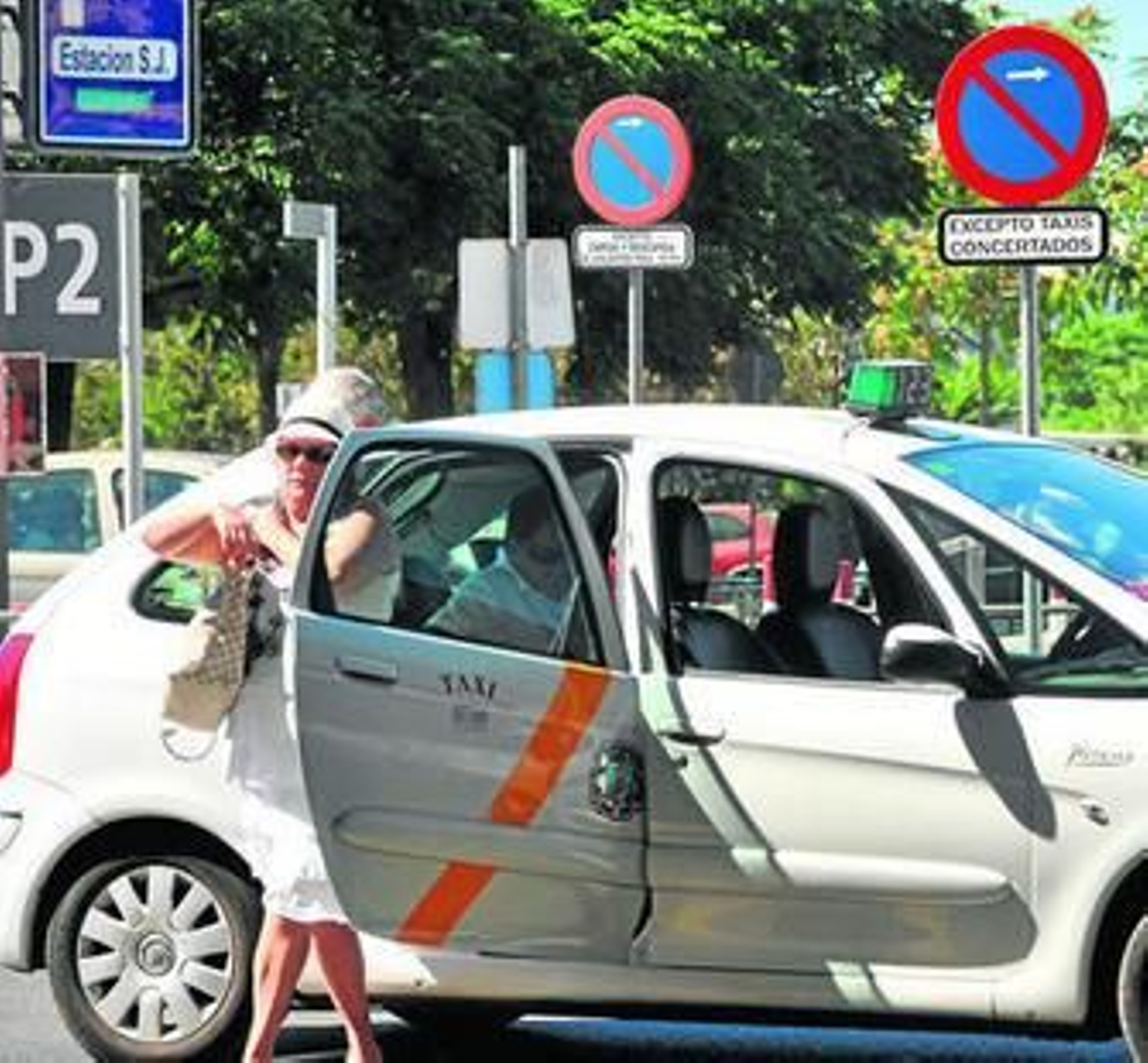 Una mujer se baja de un taxi en la parada de la estación de Santa Justa, ayer por la mañana.
