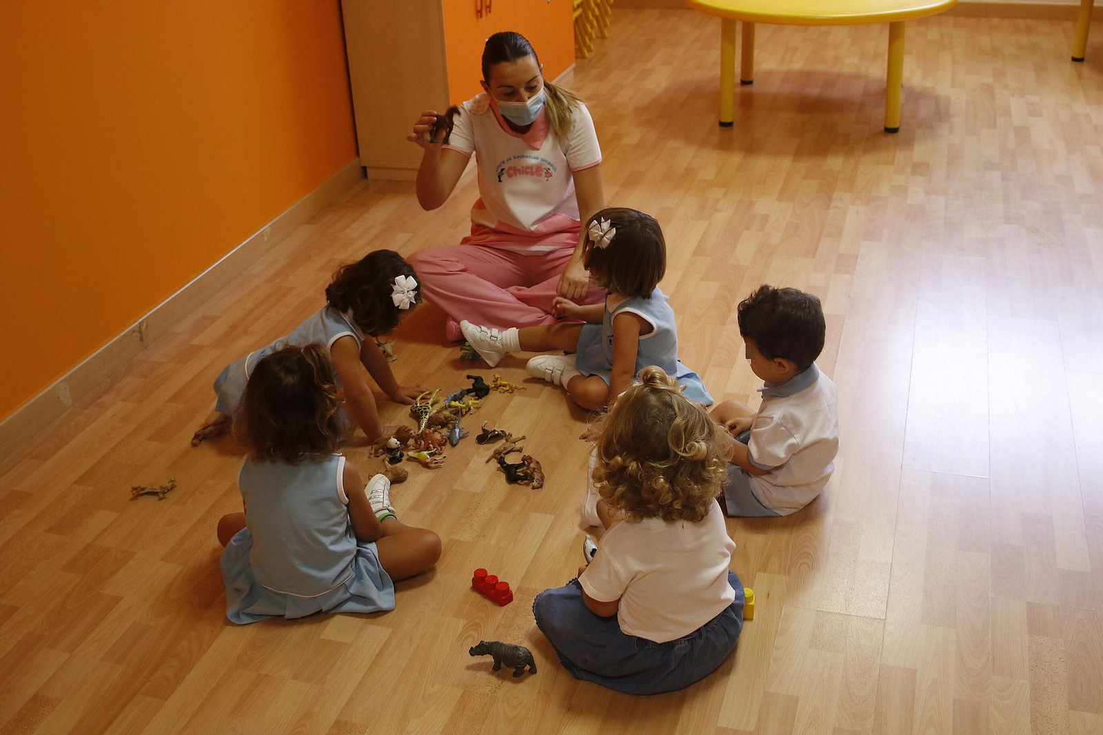 La trabajadora de una escuela infantil atiende a los alumnos.