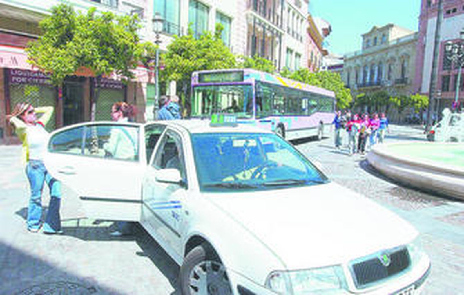 Dos usuarias se bajan de un taxi en la Rotonda de los Casinos.