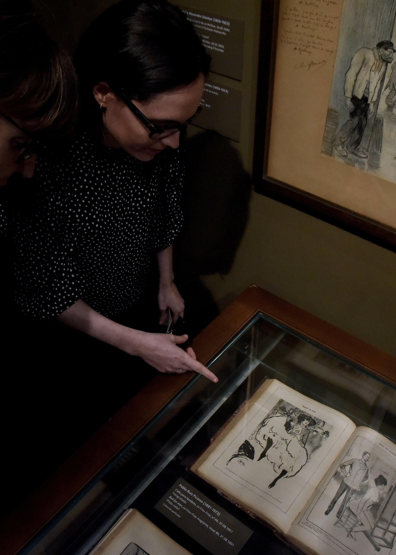 Una mujer contempla el fotograbado de Picasso que recoge la exposición.