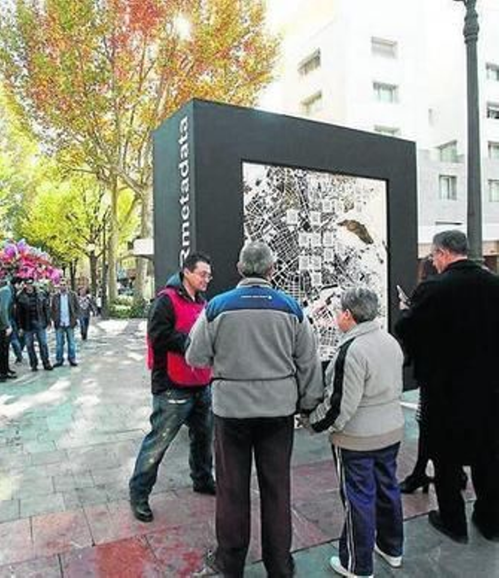 Varios ciudadanos se acercan a mirar el QR.