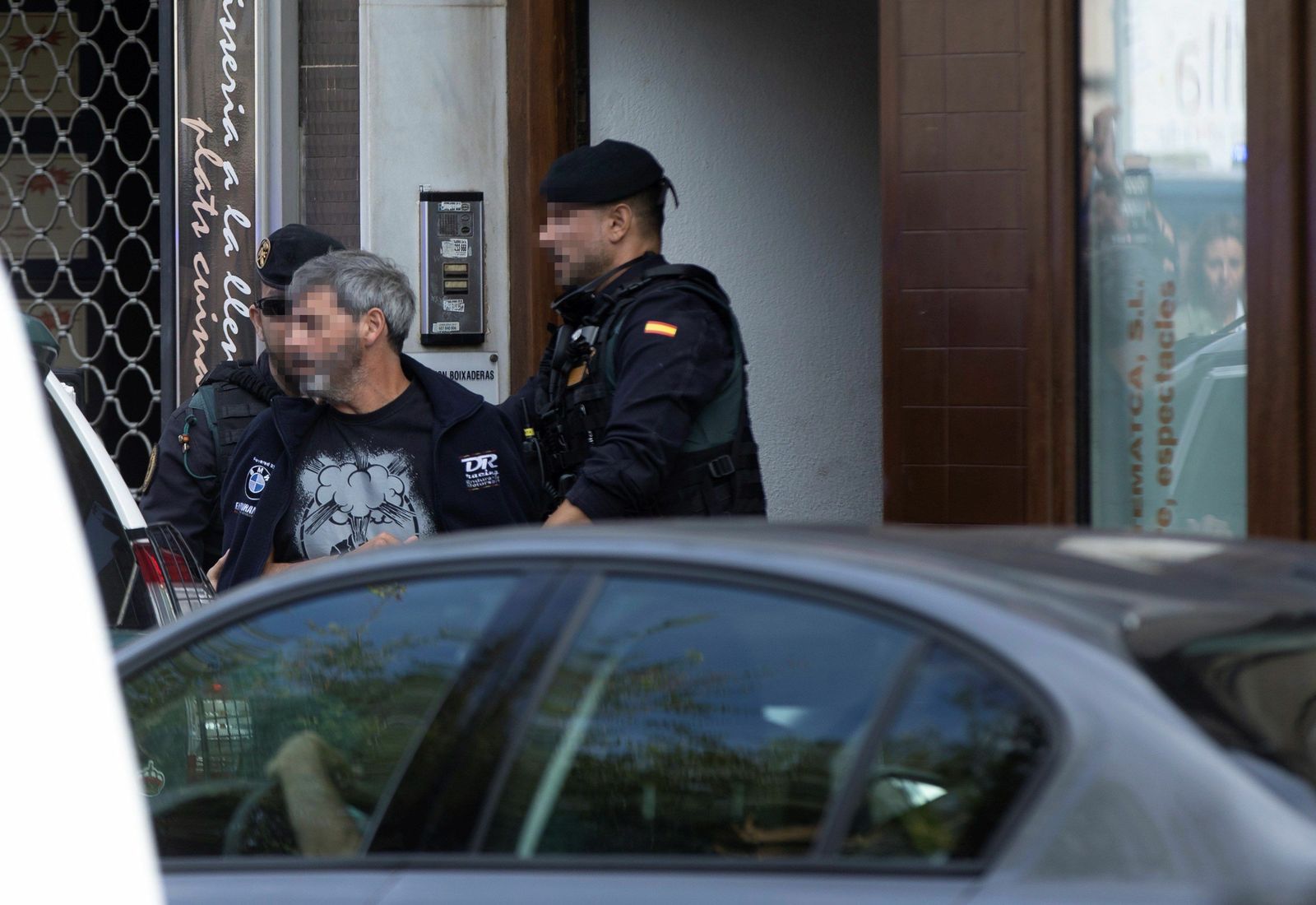 Agentes de la Guardia Civil acompañan a uno de los nueve detenidos  durante el registro de un domicilio en Sabadell.