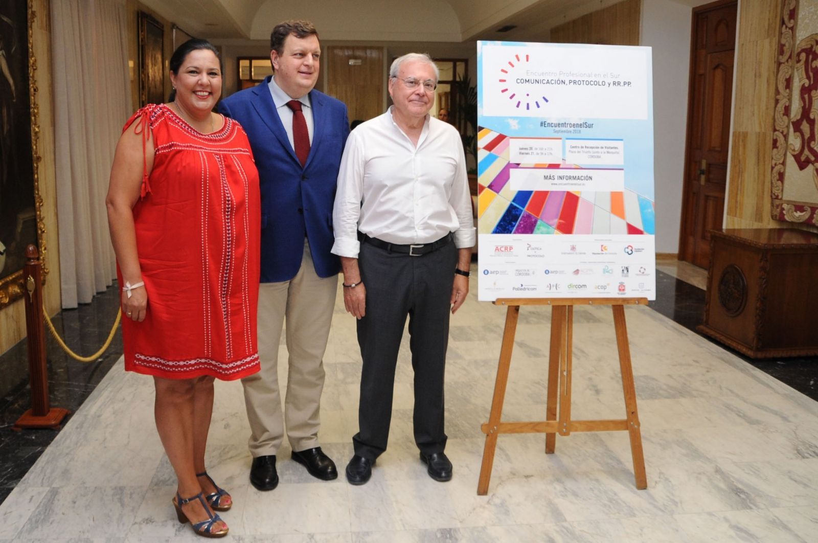 Dolores Amo. Javier Eiroa y Emilio Aumente posan con el cartel del encuentro.