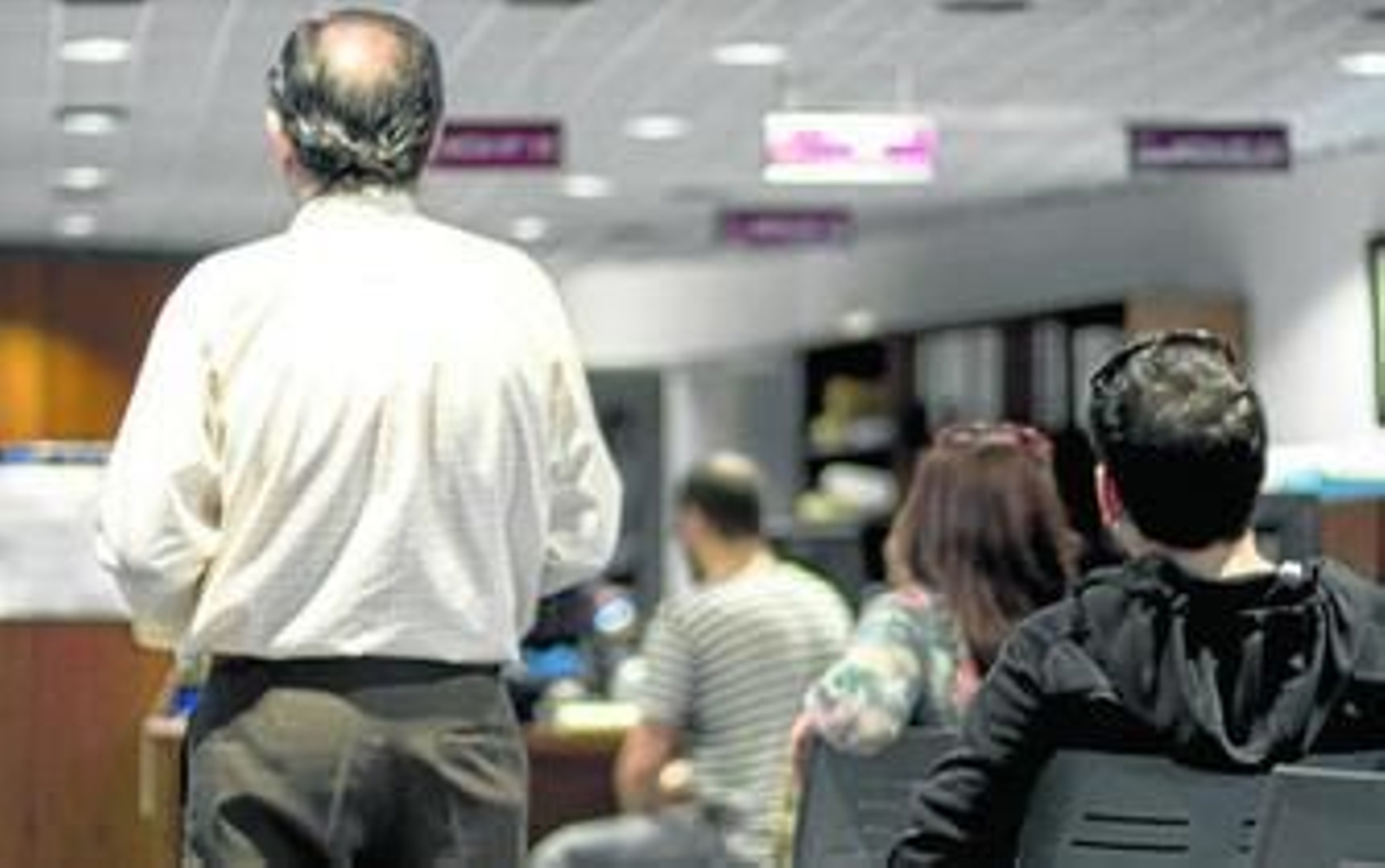 Gente a la espera de informarse sobre pagos de tasas e impuestos en la planta baja del Ayuntamiento.