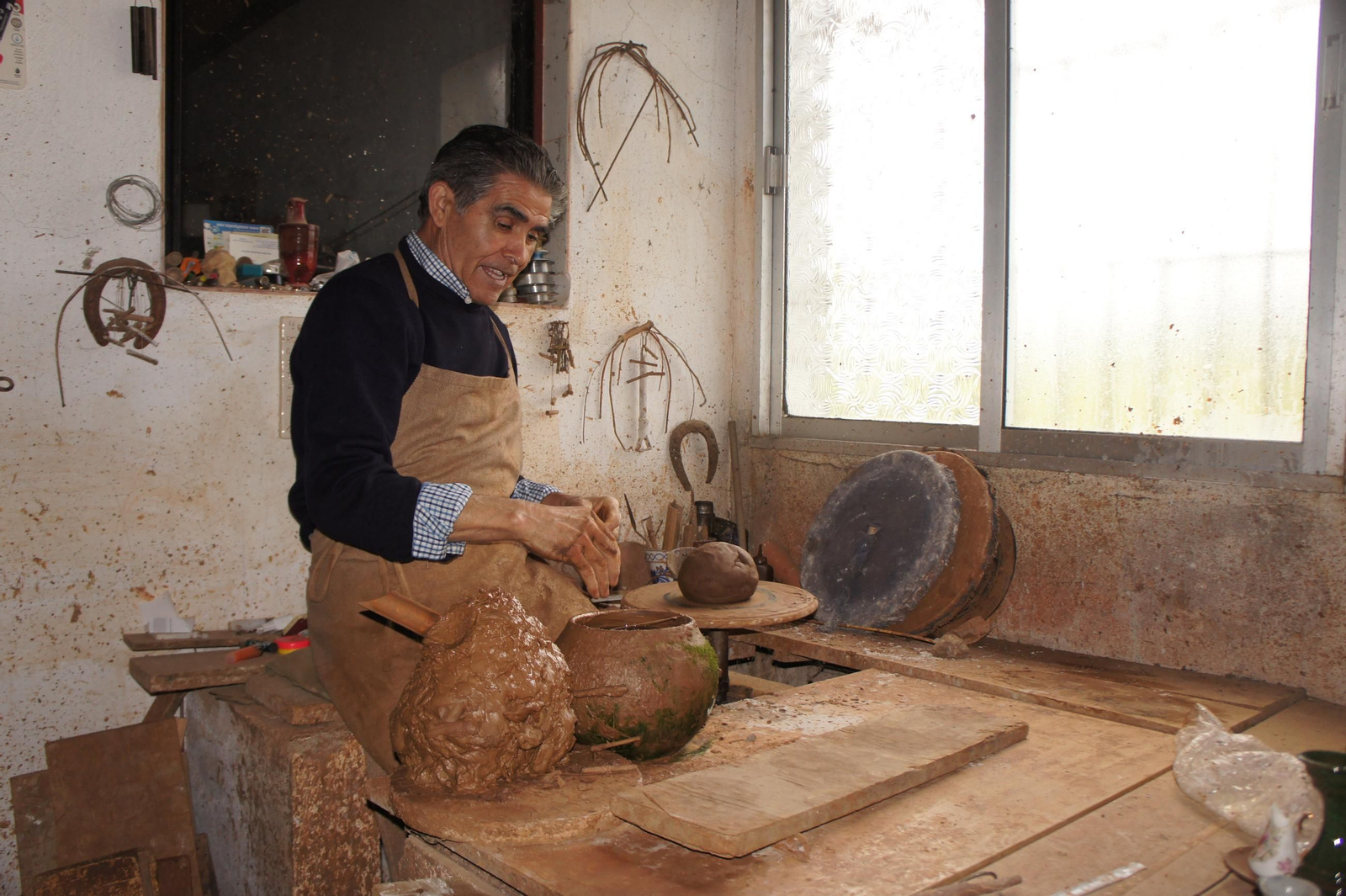 Hipólito Escudero, en el torno de su taller comenzando a moldear una pieza.