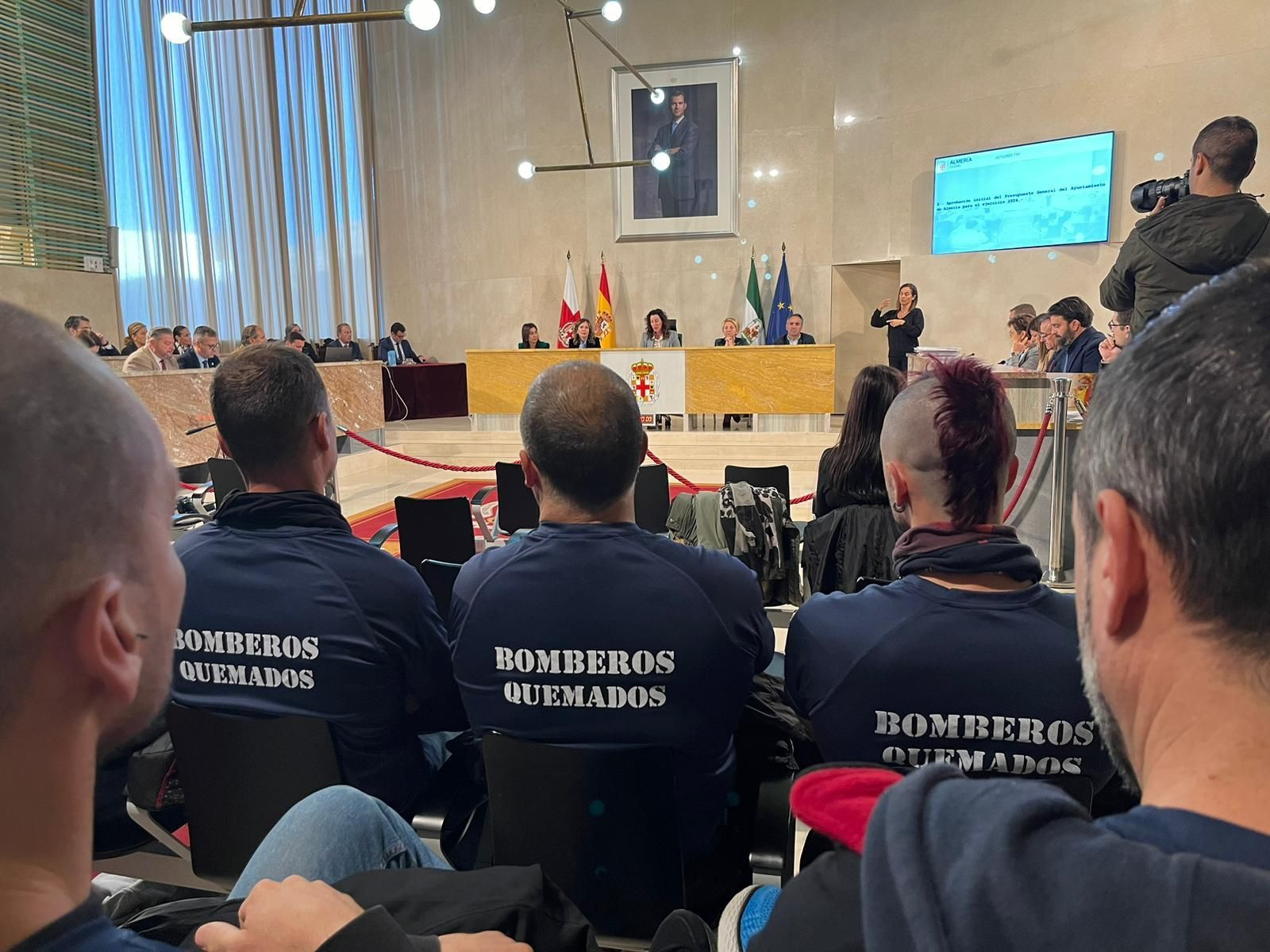 Bomberos en el Salón Noble de Plenos con las camisetas reivindicativas.