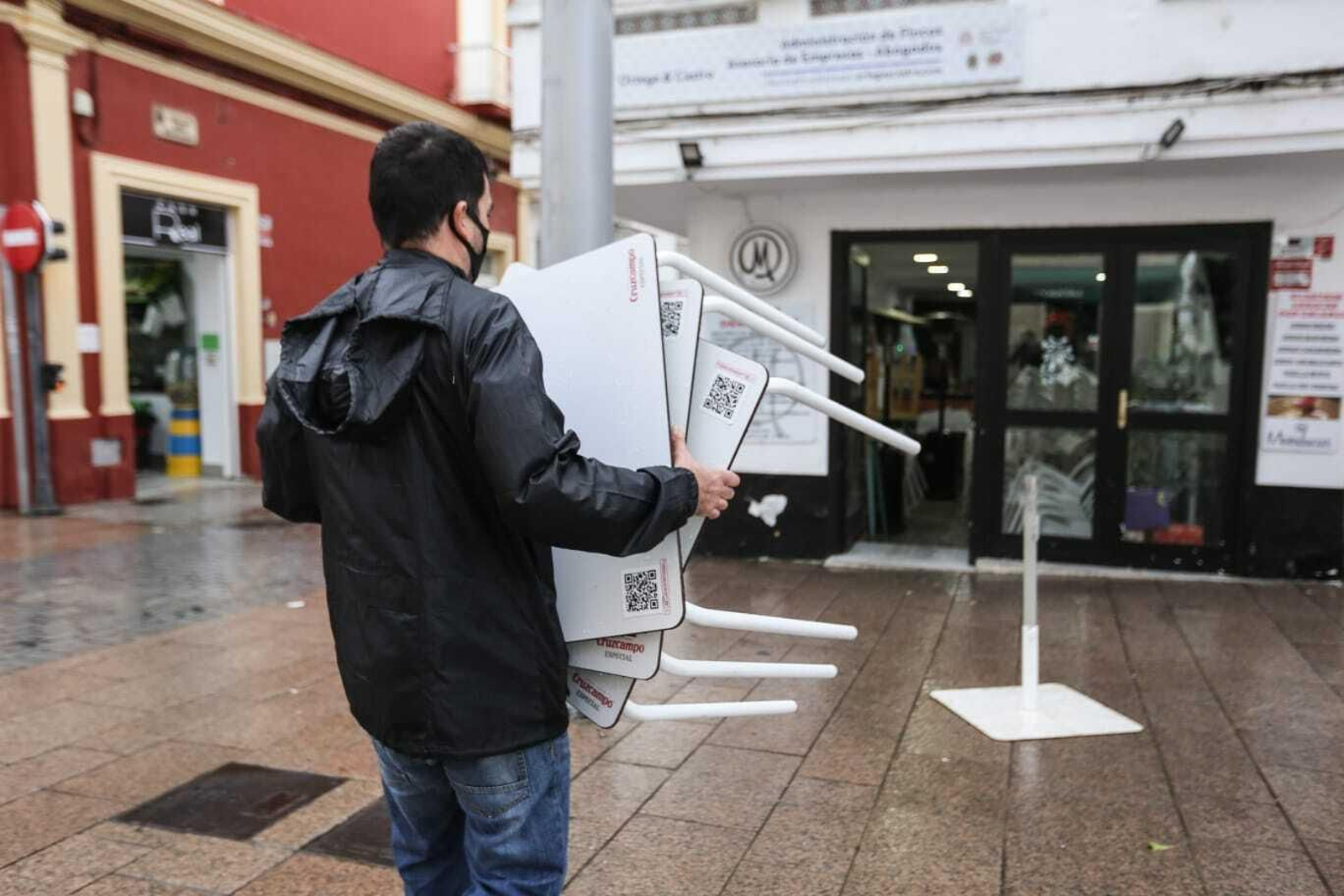 Un hostelero recoge su terraza en San Fernando al llegar las seis de la tarde.