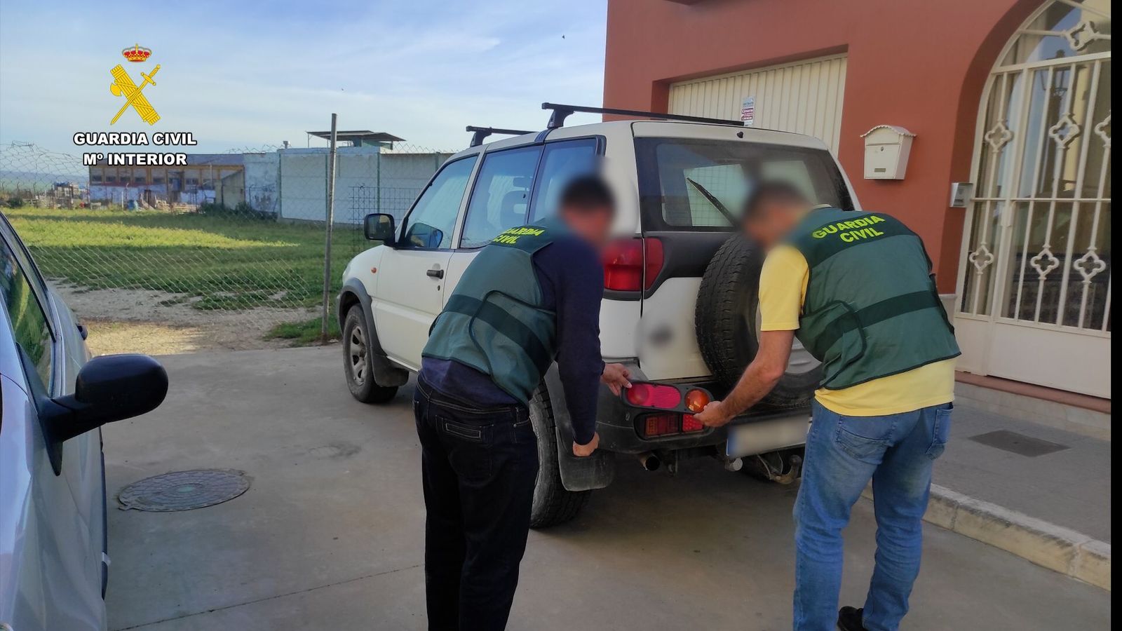 Agentes de la Guardia Civil con uno de los vehículos que sufrió el robo.