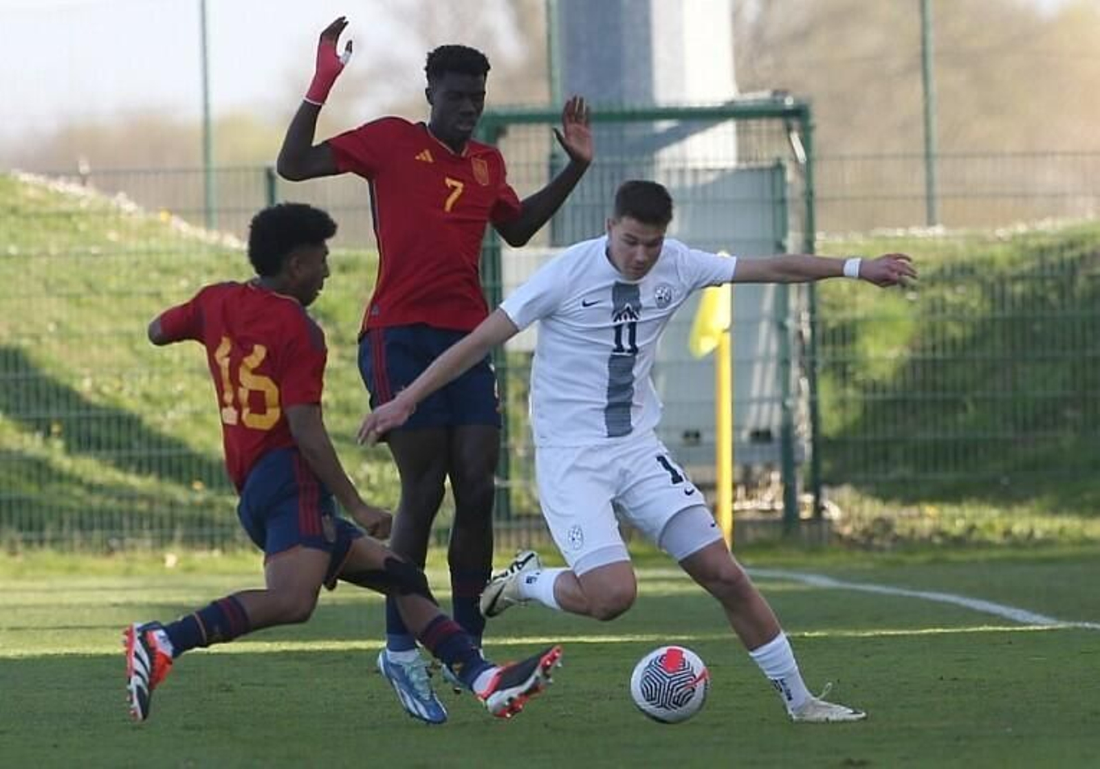 Cristian David presiona a un jugador esloveno durante un partido de la selección española sub-19.