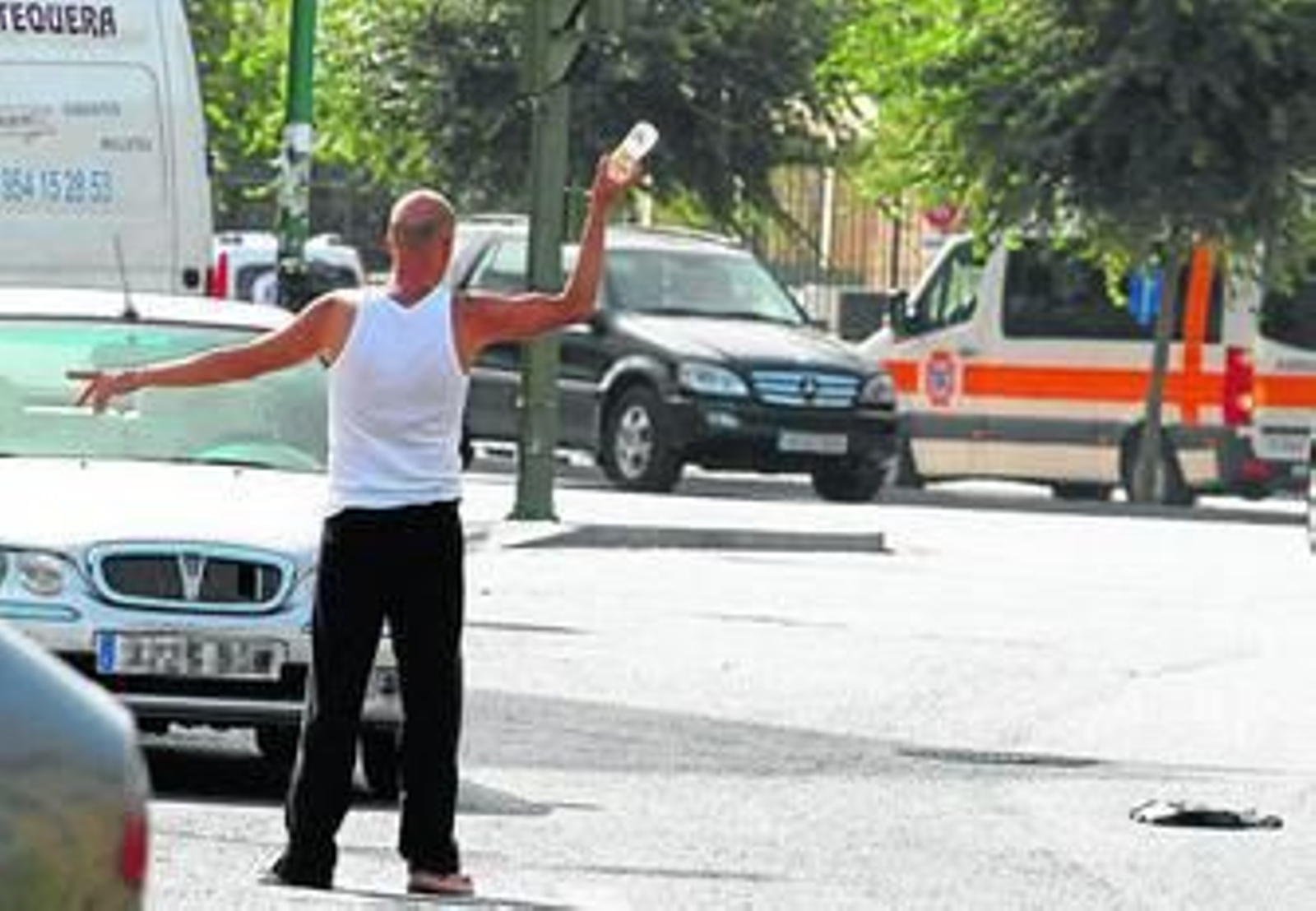 Un 'gorrilla' hace indicaciones a los vehículos para que estacionen.