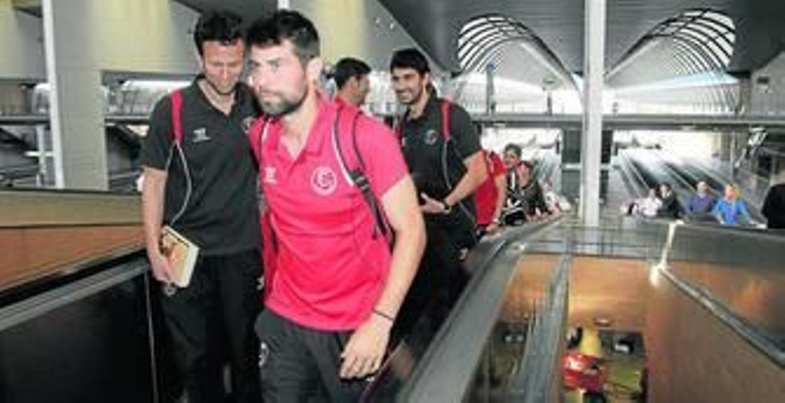 Coke, otro de los futbolistas pendientes de su renovación, el doctor Juan José Jiménez y el nutricionista Felipe del Valle, a la llegada a Santa Justa tras el largo viaje desde Malasia.