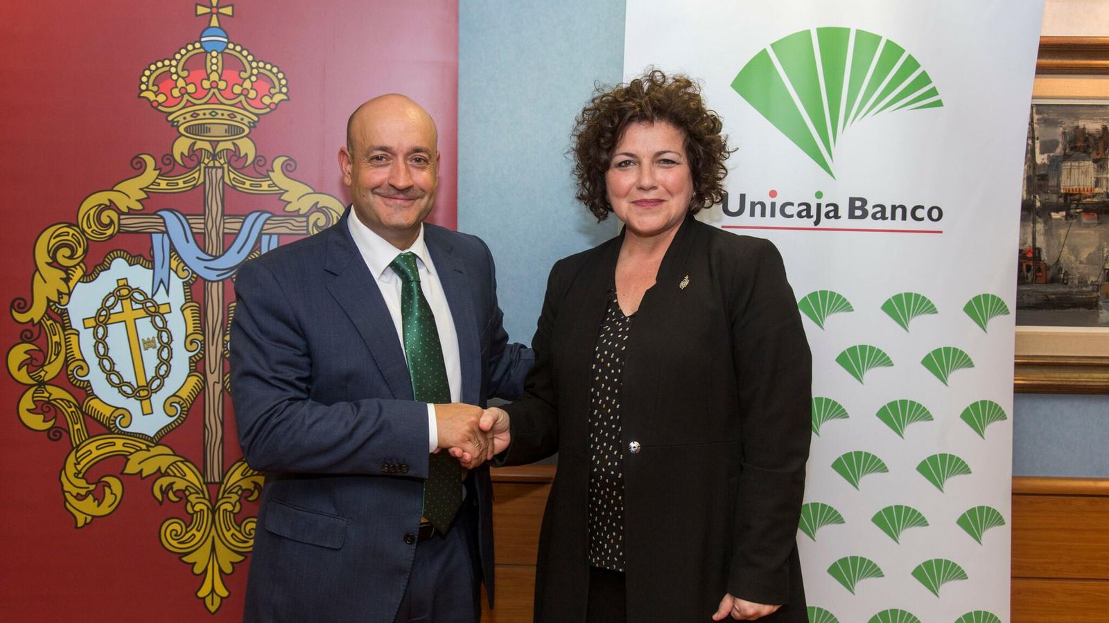 Director y presidenta estrechan la mano.