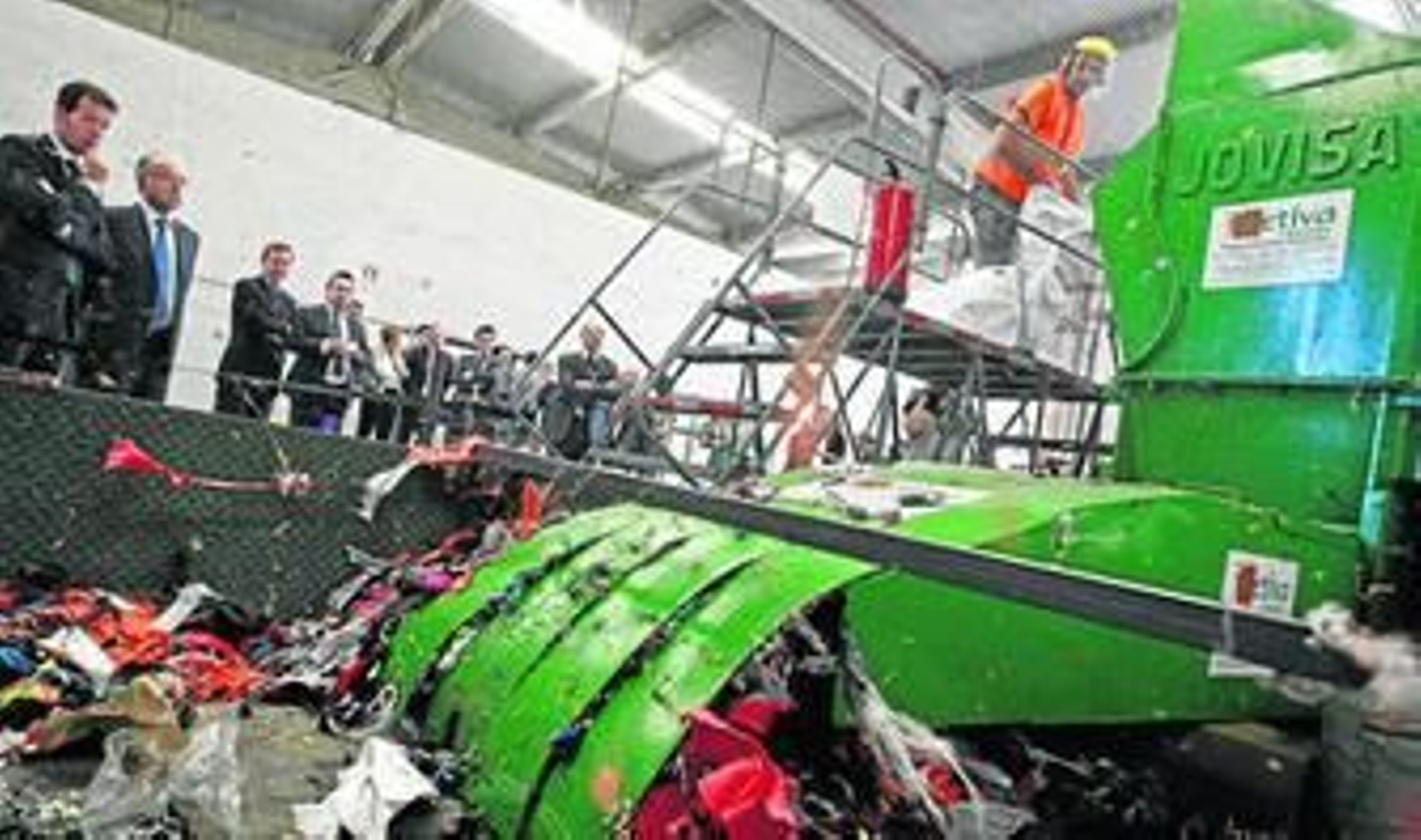 Las autoridades miran cómo la trituradora deshace en hilachas y pelusas prendas deportivas falsificadas, ayer en la nave de la Agencia Tributaria.