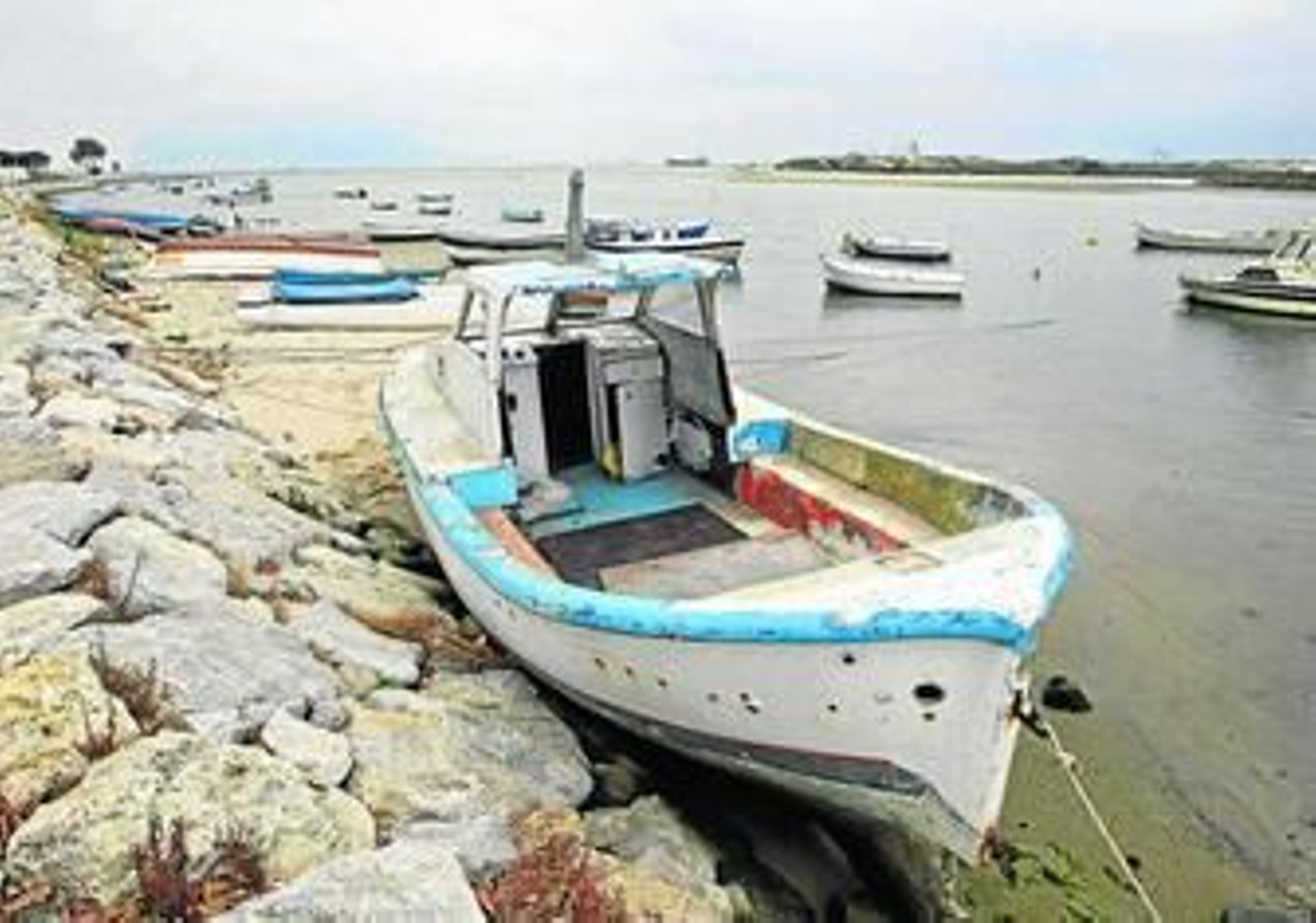 Embarcaciones amarradas a las piedras y fondeadas en el río Palmones.