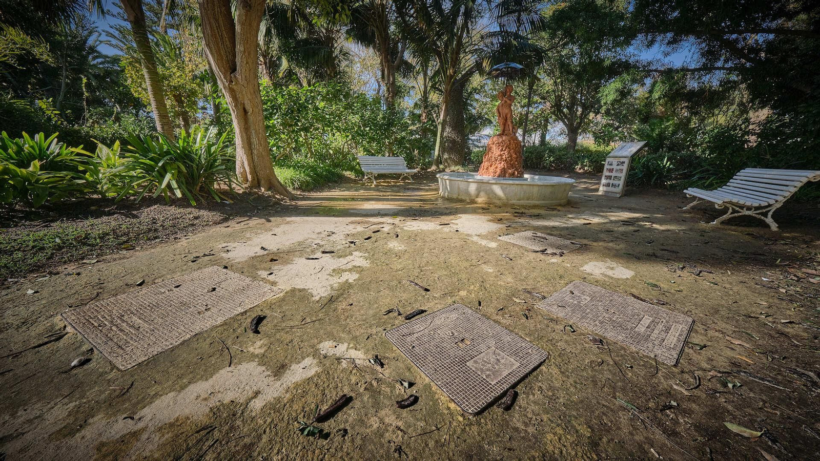 Arquetas que el paso del tiempo ha hecho aflorar debajo del albero junto a la fuente de los niños bajo el paráguas.