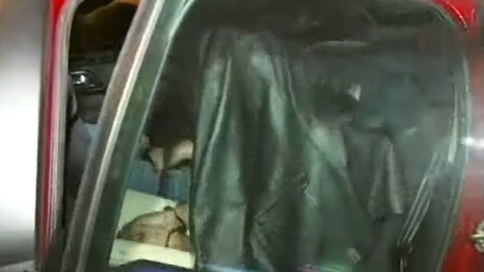 El detenido, en un vehículo camuflado de la Policía, con la cabeza cubierta por una chaquera de cuero.