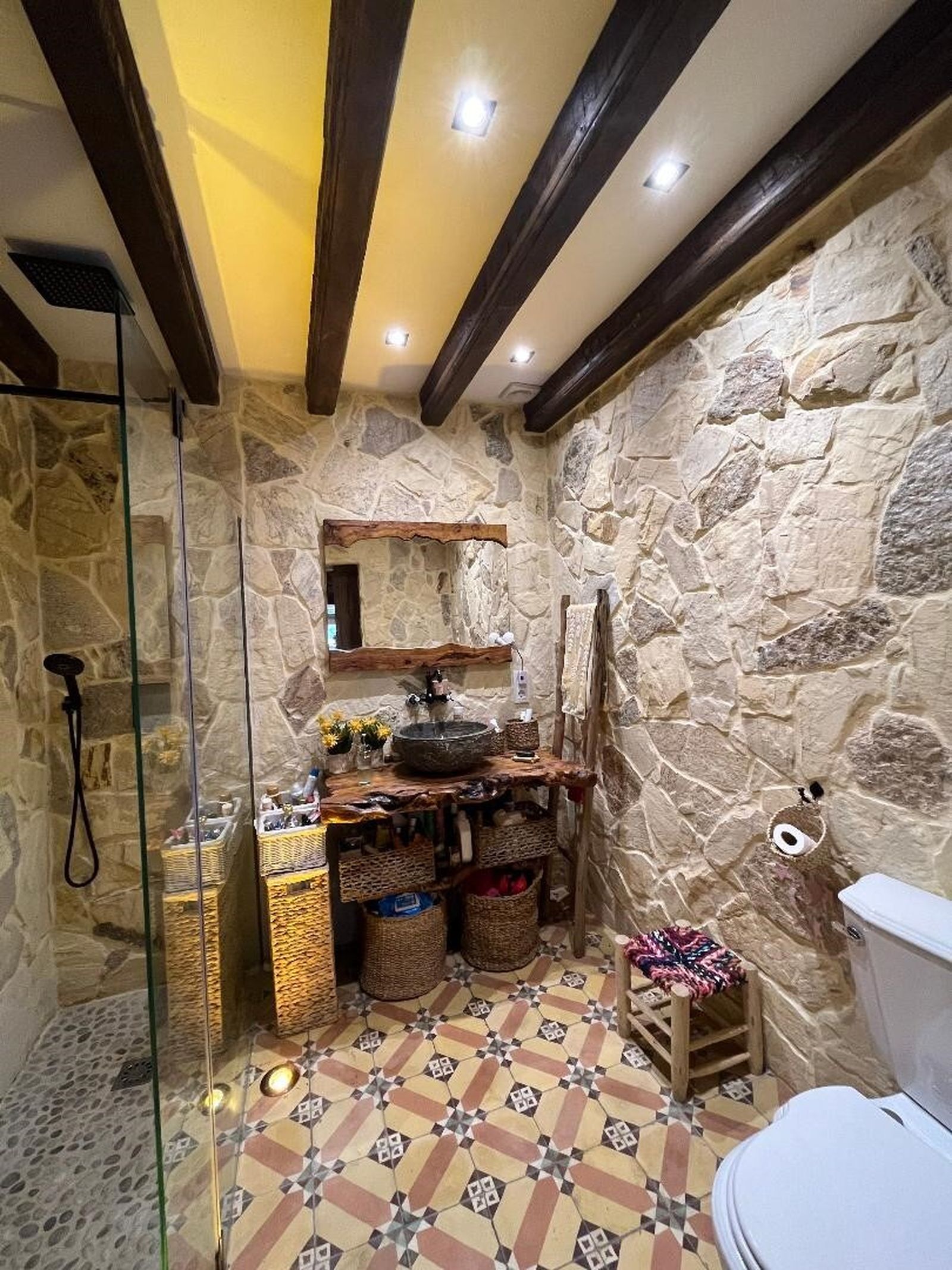 Baño. Un lavabo de piedra natural se apoya sobre una encimera de pino natural.