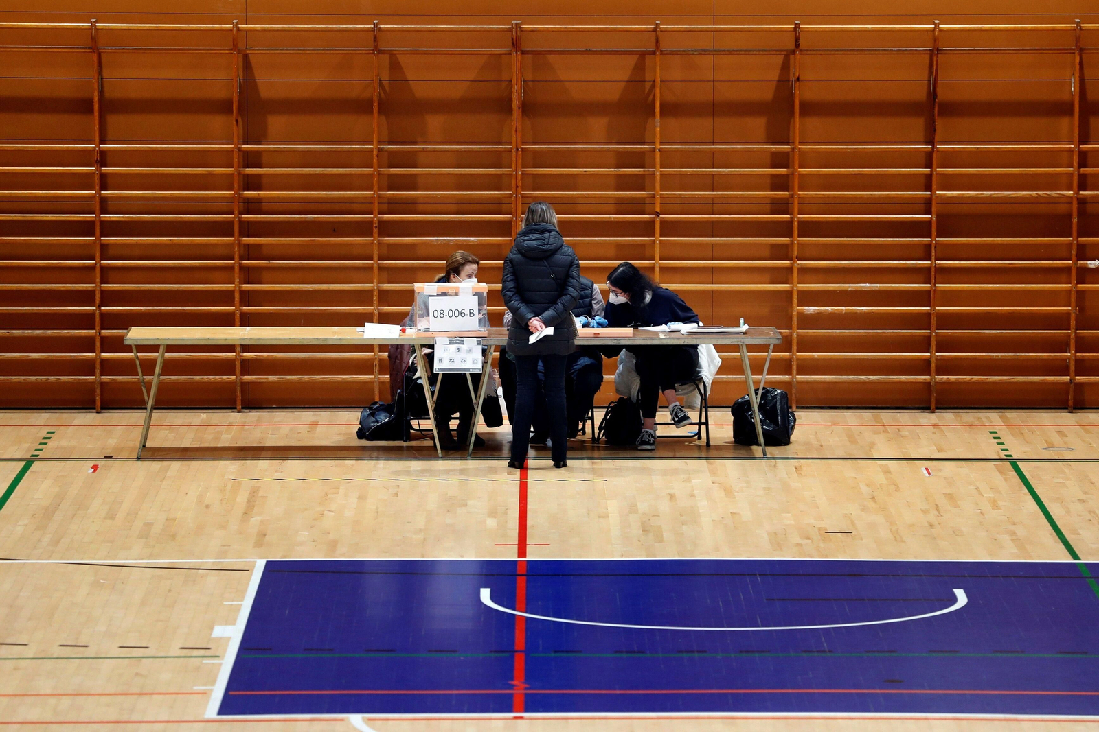 Una persona se dispone a votar en el Polideportivo Municipal Virrey Amat Can Ricart de Barcelona.