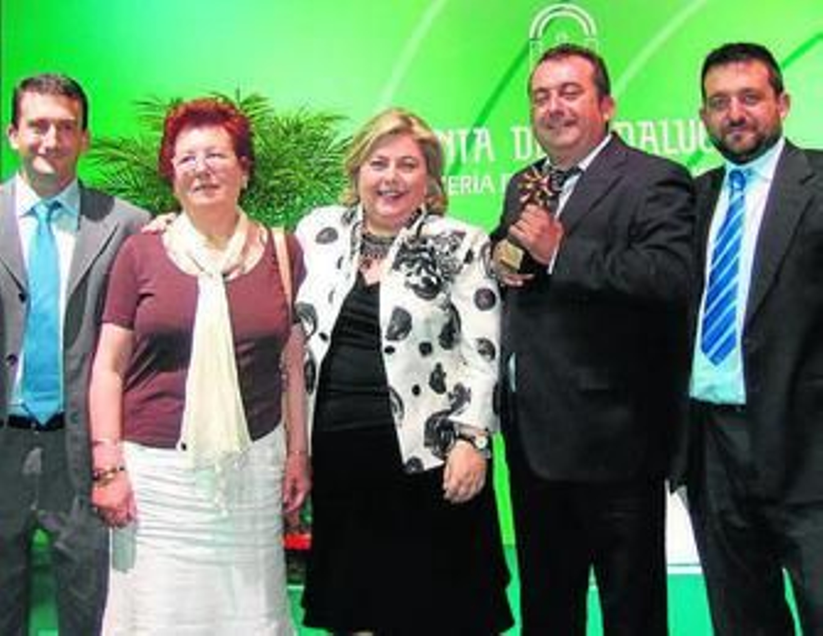 En el centro, la consejera con a los tres empresarios y su madre.