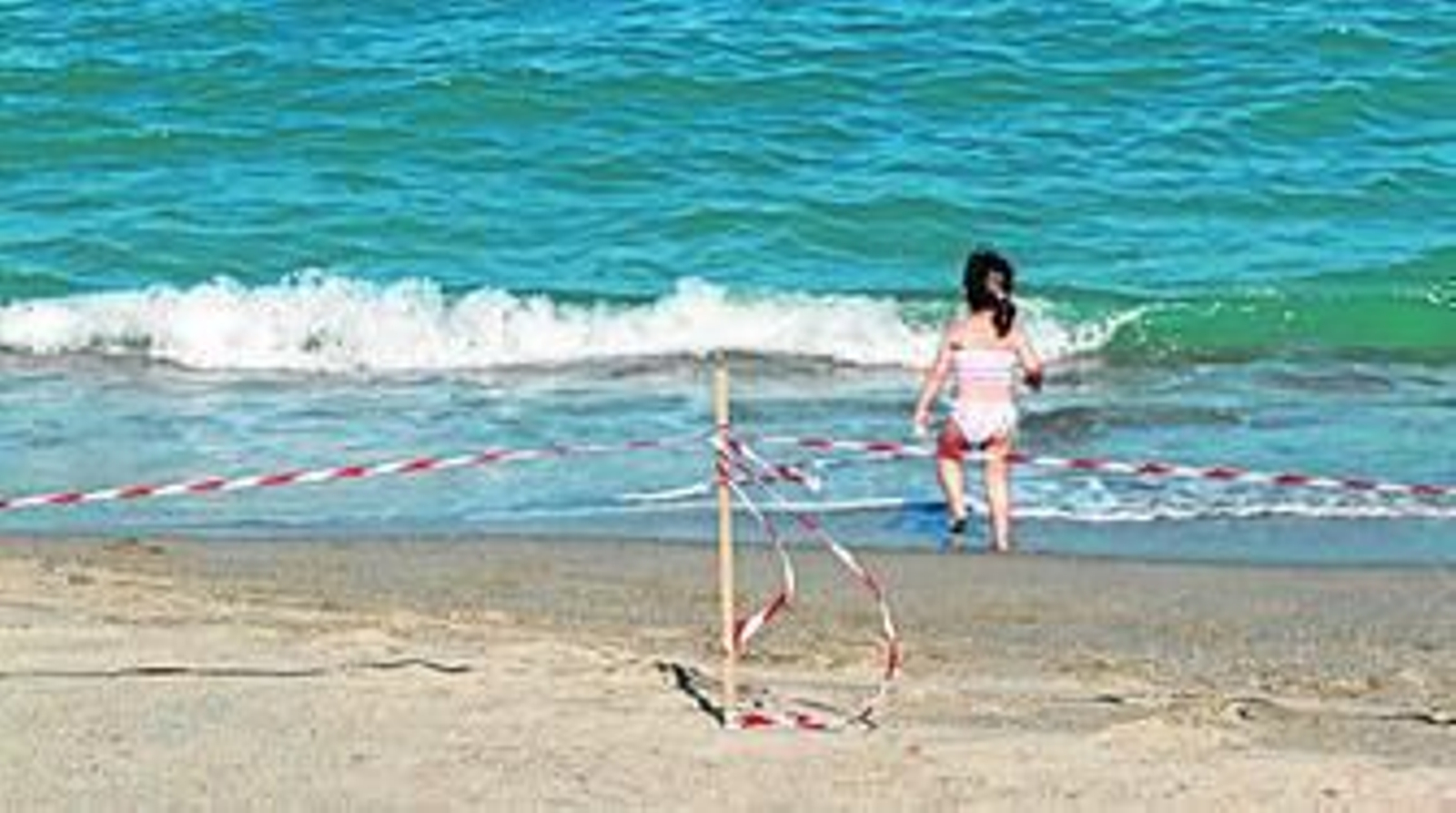 Una niña jugando en la orilla del tramo de playa cerrado al baño durante la tarde de ayer.