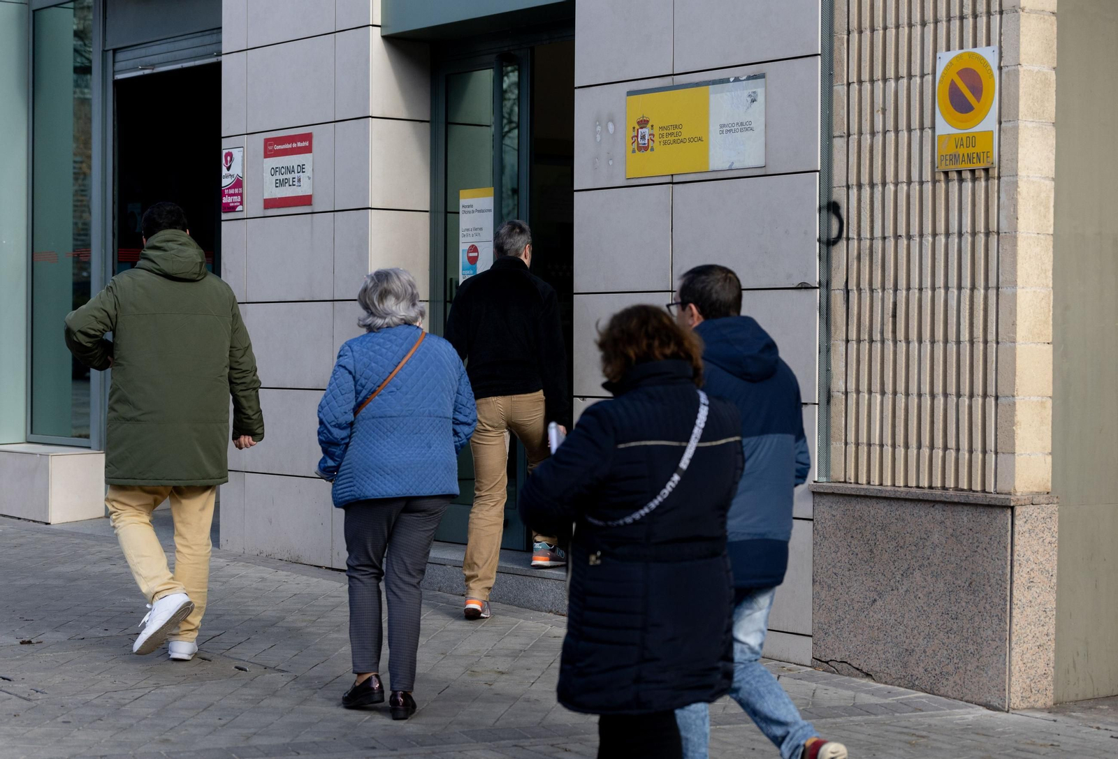 Varias personas pasan ante una oficina de empleo en Madrid.