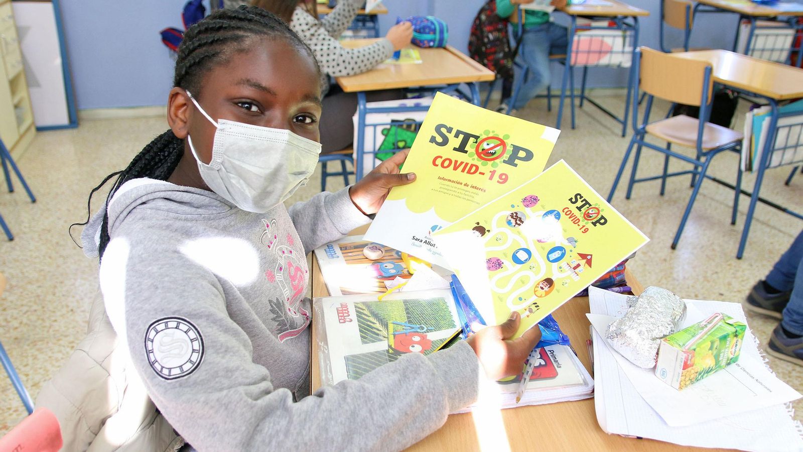 Una niña muestra los materiales repartidos en el colegio por la asociación 'Sara Allut Plata'