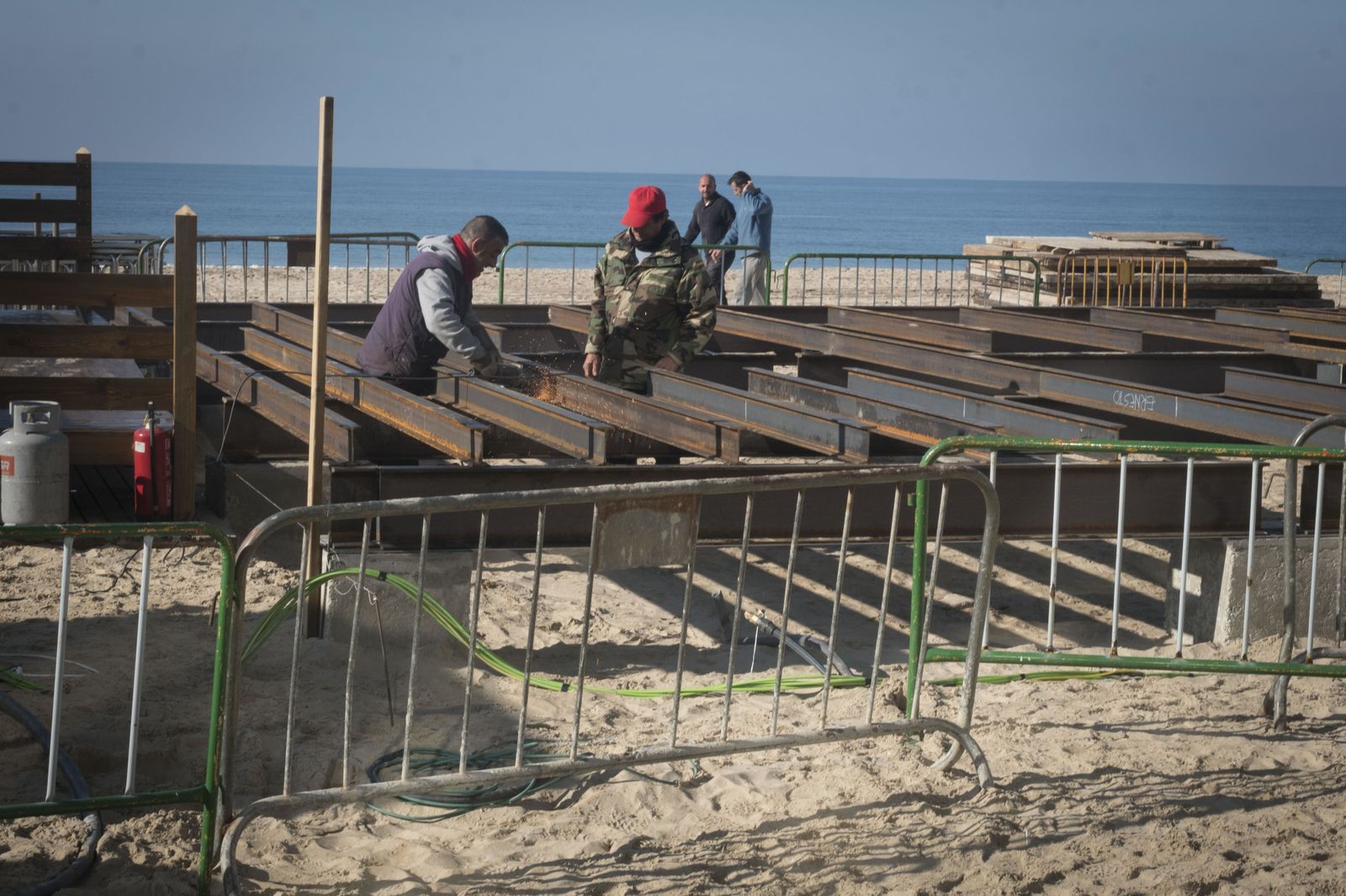 Trabajadores, durante el montaje de la estructura de la plataforma del nuevo chiringuito, en una imagen tomada ayer por la mañana.