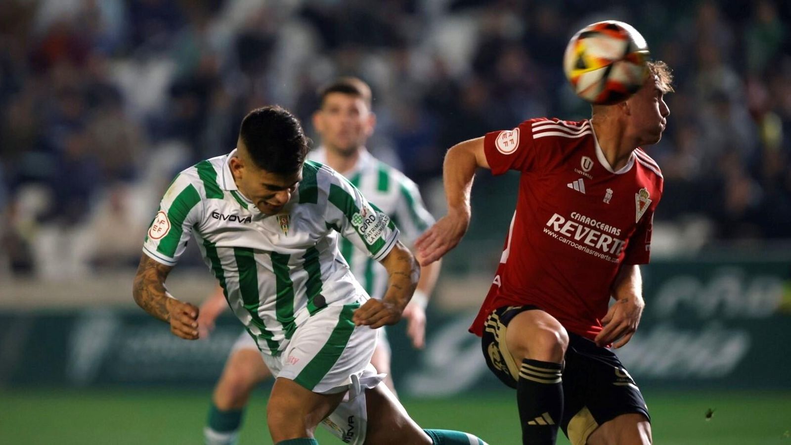 Kuki Zalazar remata de cabeza ante Alberto en el primer tiempo del Córdoba CF - Real Murcia.