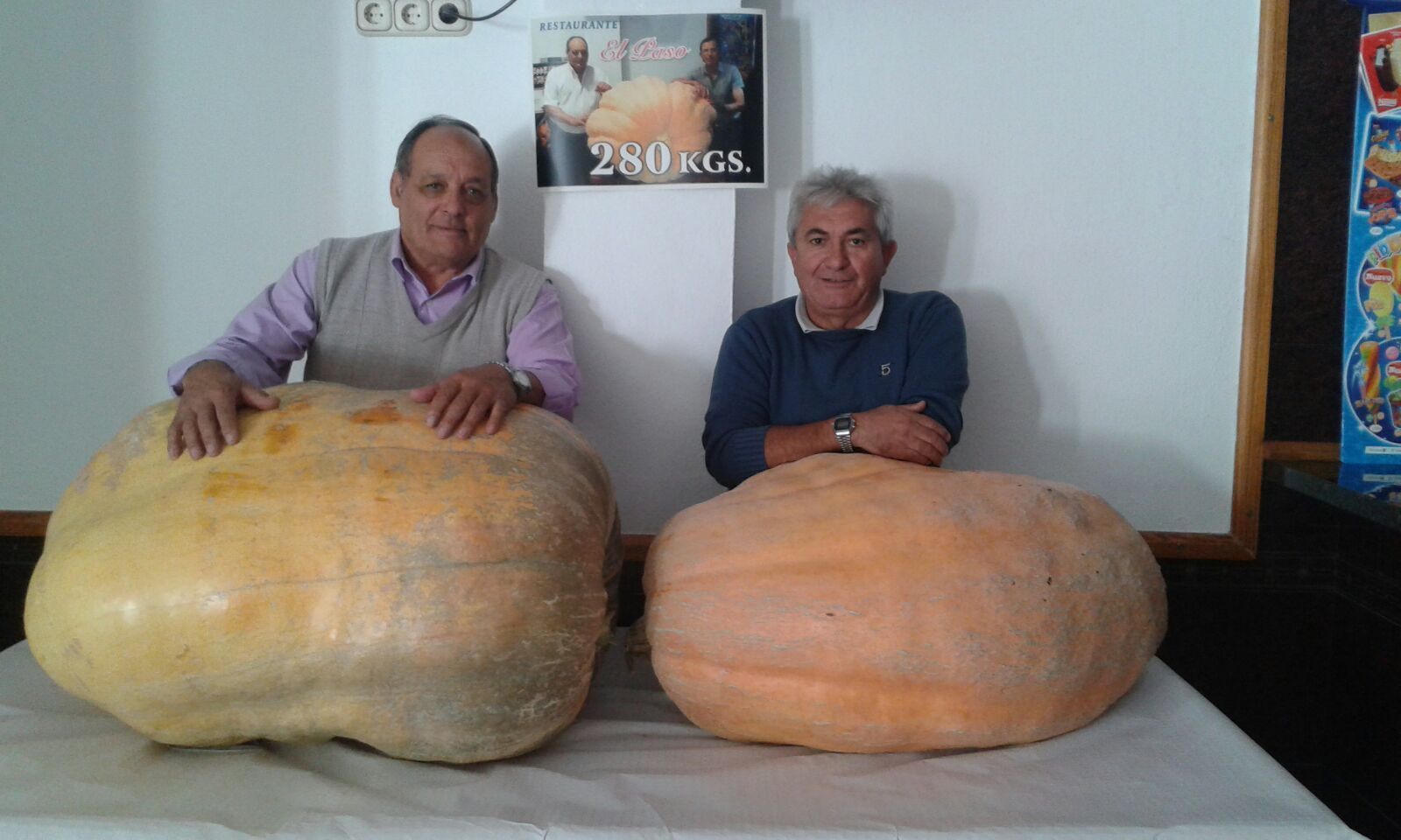 Antonio Navarro y Antonio Encinas posan con las dos calabazas gigantes que se pueden ver en el restaurante El Paso.