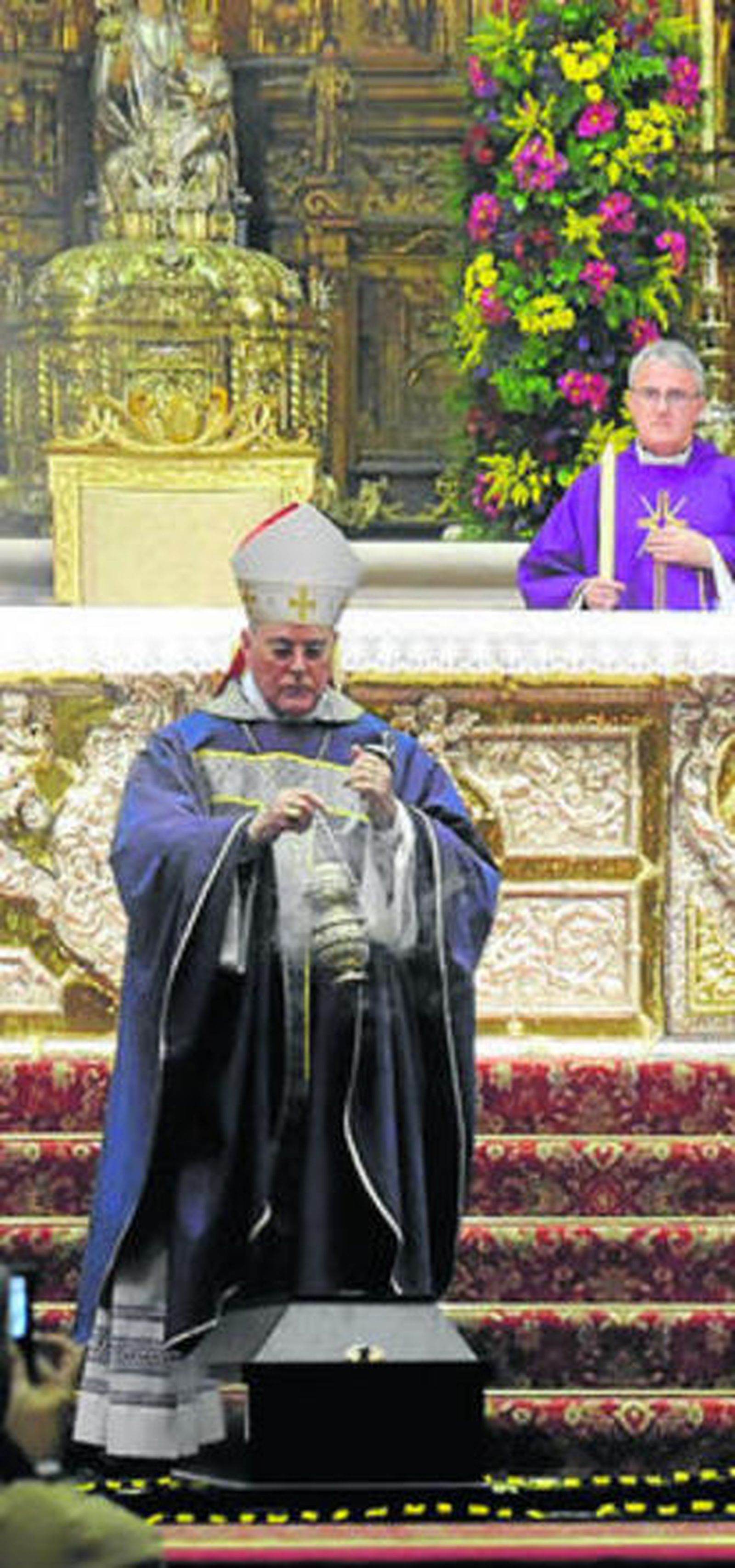 El cardenal inciensa el féretro en el altar mayor.
