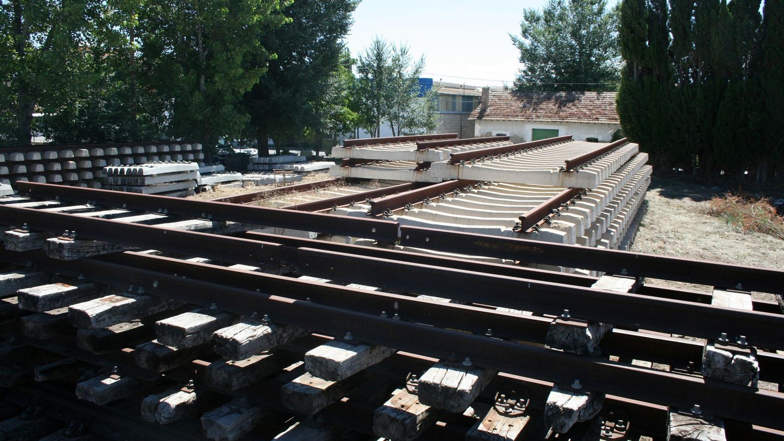 Material ferroviario acopiado junto a las vías del tren.