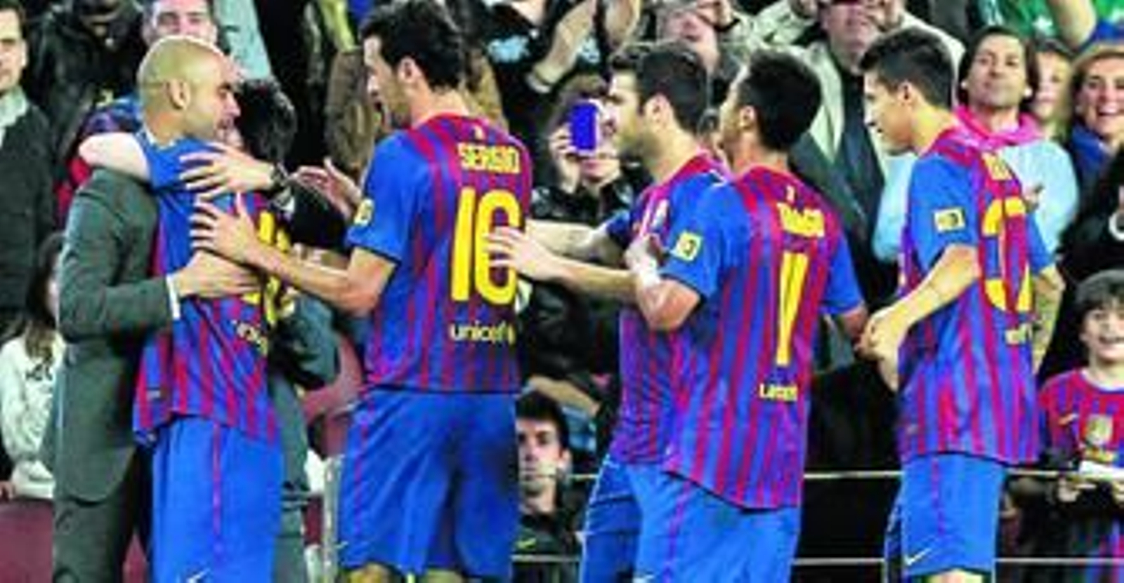 Messi, escoltado por el resto de los jugadores barcelonistas, abraza a Guardiola tras anotar uno de sus goles frente al Espanyol.