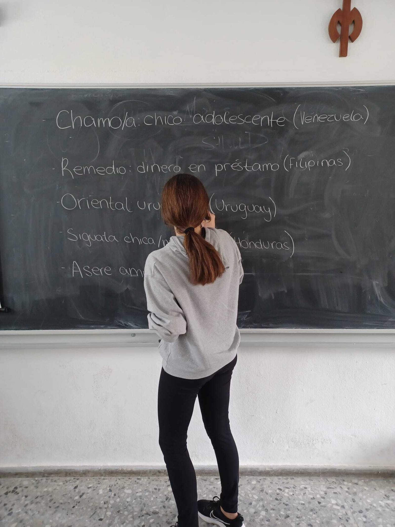 Una alumna escribiendo en una pizarra.