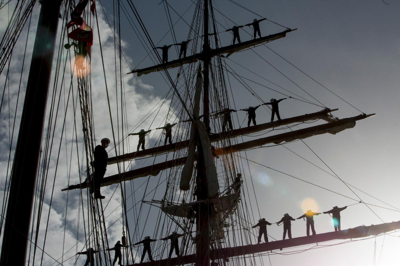 La tripulación del buque escuela en sus palos a la salida del muelle de Cádiz.