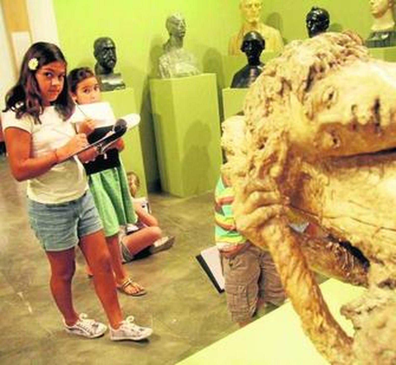 Un grupo de niños junto a una escultura romana del Museo Arqueológico.