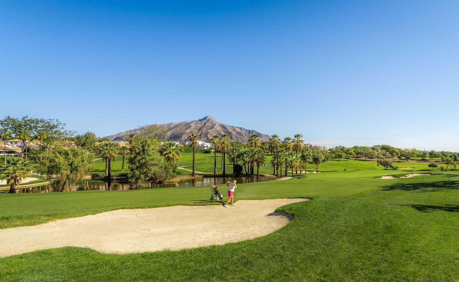 Una mujer jugando al golf en un campo de Marbella.