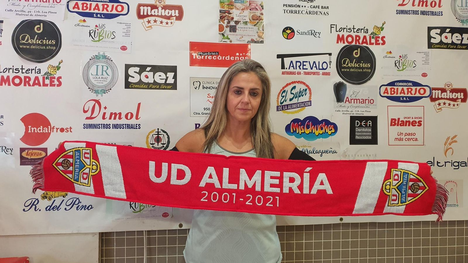 Con su bufanda rojiblanca ante el cartel con los patrocinadores.