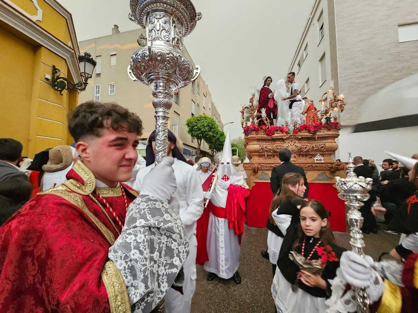 Un integrante del cuerpo de acólitos de la Borriquita llora mientras un costalero cubre la imagen del Cristo.