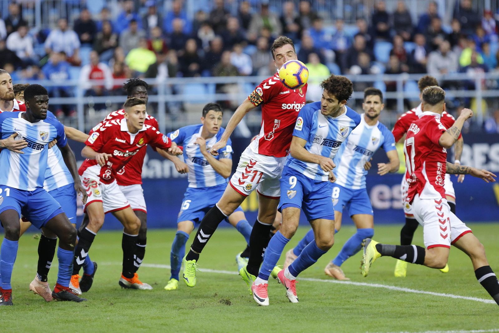 El malaguista Gustavo Blanco intenta rematar en el área ante Manu Barreiro.