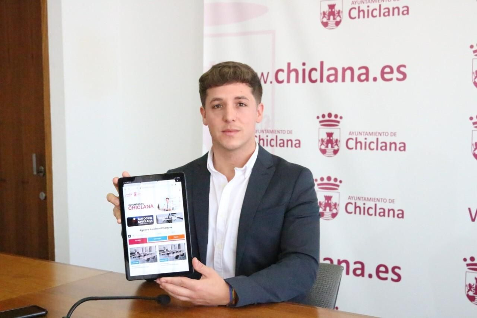 El edil José Alberto Cruz muestra en una tablet la nueva página web del área de Juventud.