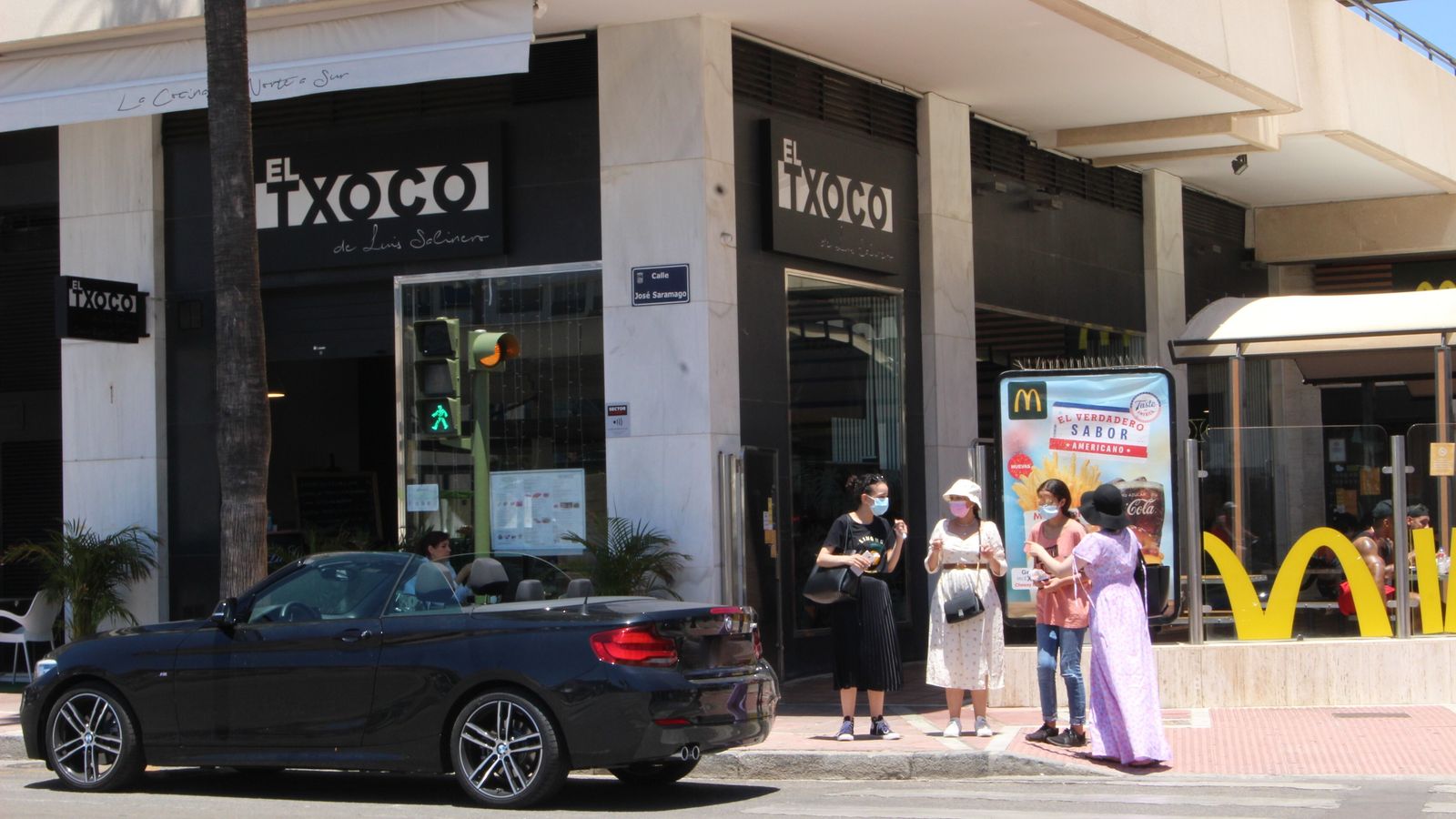 Vista de transeúntes en la avenida Julio Iglesia de Puerto Banús, en Marbella.