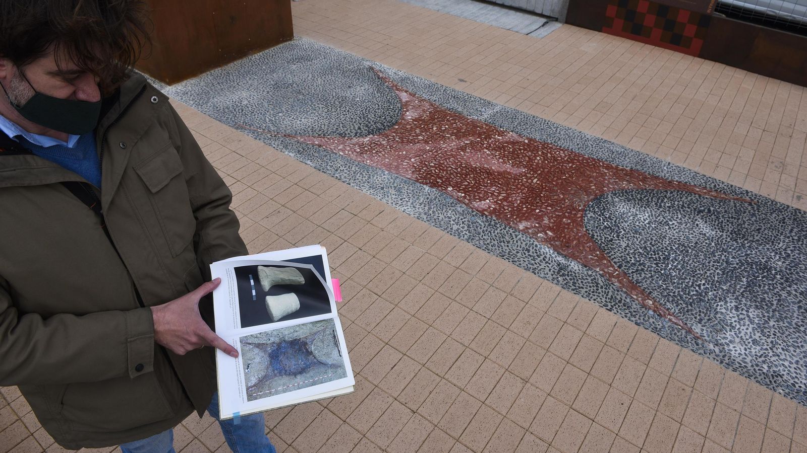 La zona central del paseo, que reproduce con cantos rodado y el tono rojizo, el altar del templo, como aparece en una fotografía de Tartessos Desvelado, el libro de los arqueólogos que lo excavaron Álvaro Fernández y Araceli Rodríguez.