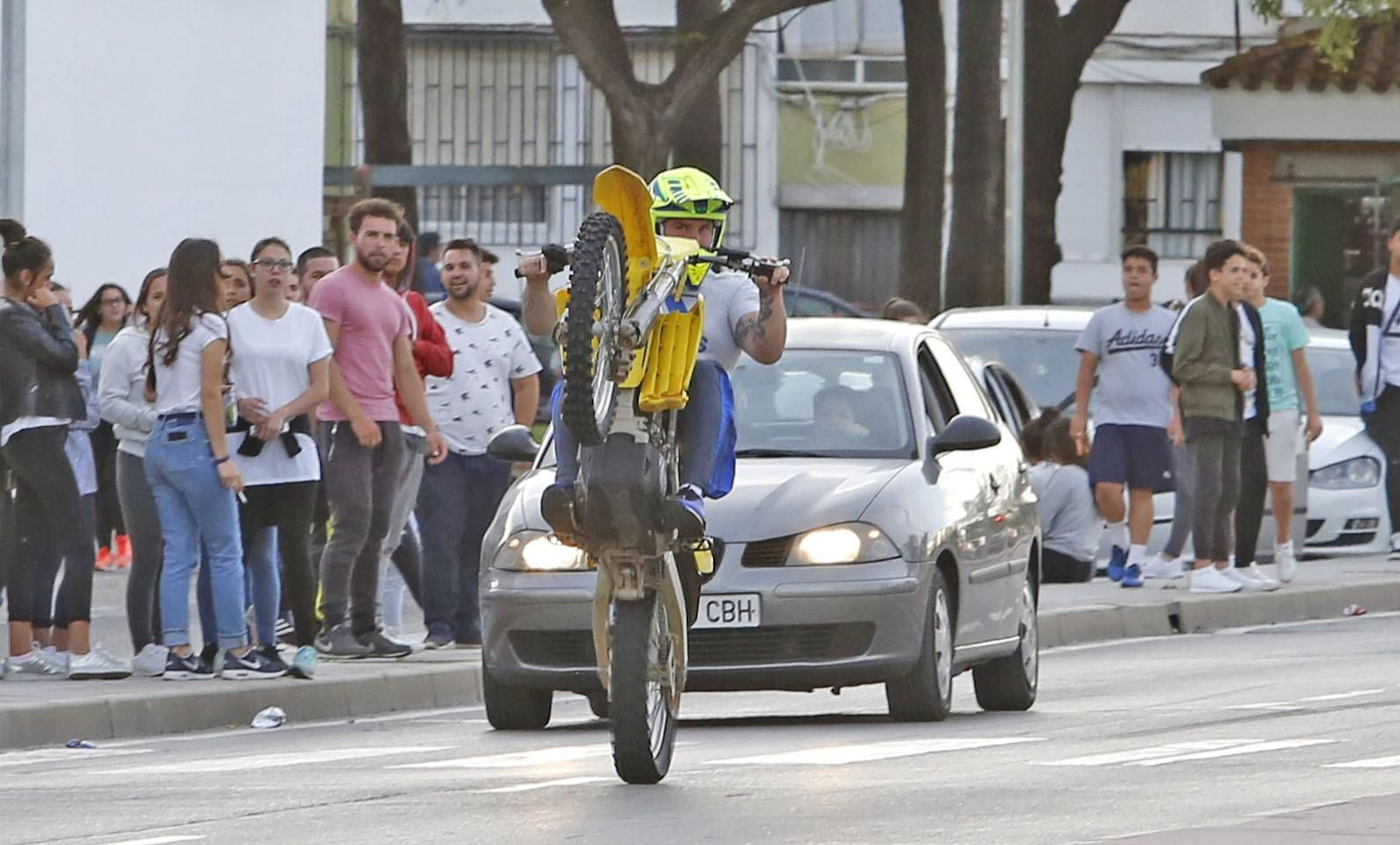 Un joven realizando ayer un 'caballito' en la avenida Blas Infante, ante la mirada de otros jóvenes.