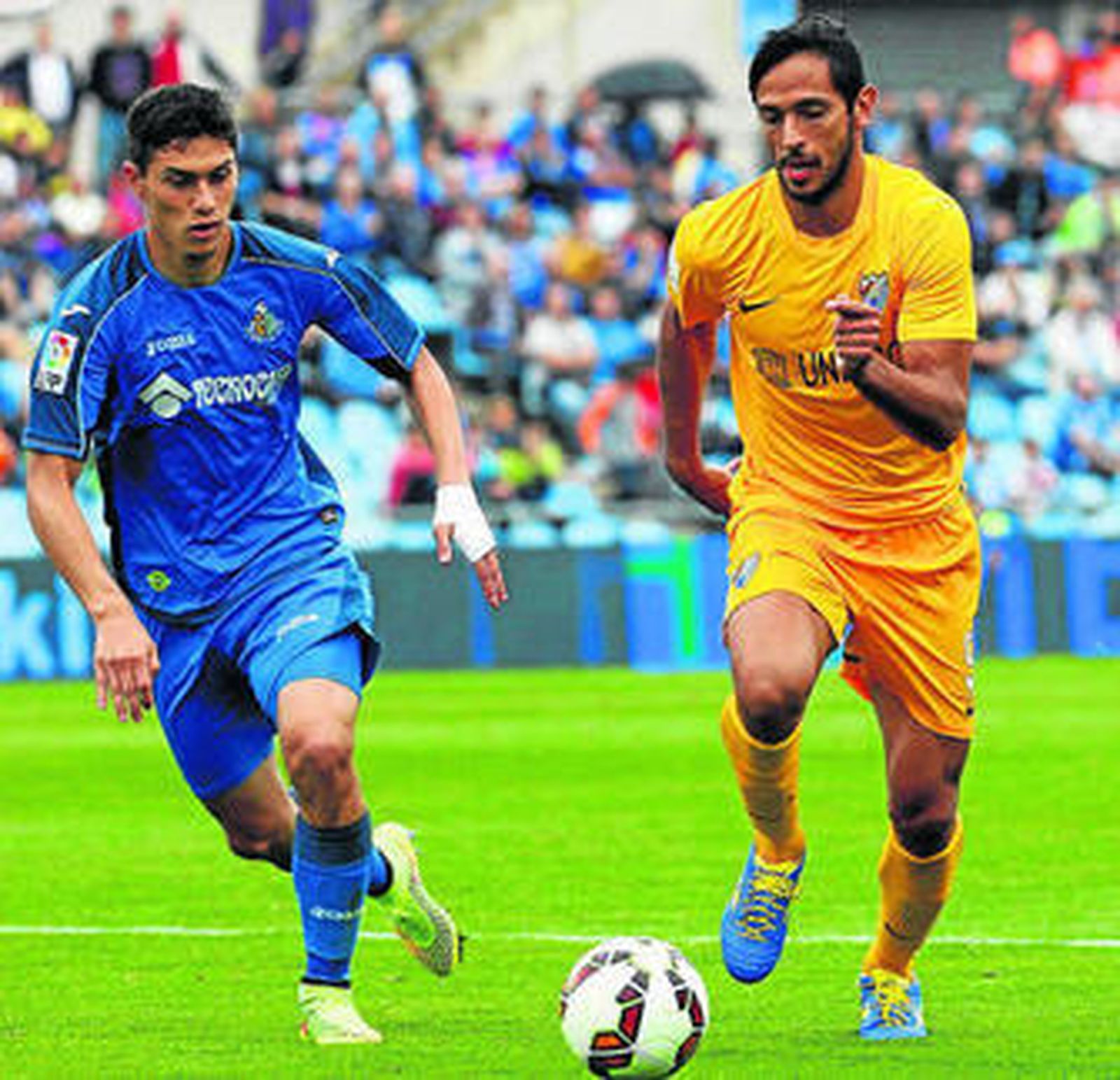 El central del Getafe Emiliano Velázquez trata de arrebatar el balón al delantero malacitano Santa Cruz.
