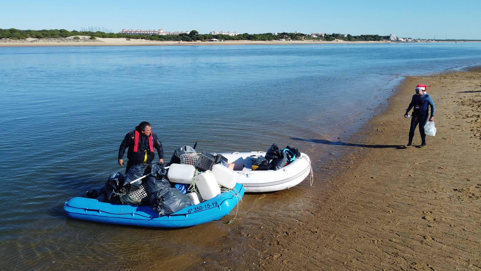 Las mejores imágenes de los Papás Noel que ha cruzado el río Piedras en paddle surf