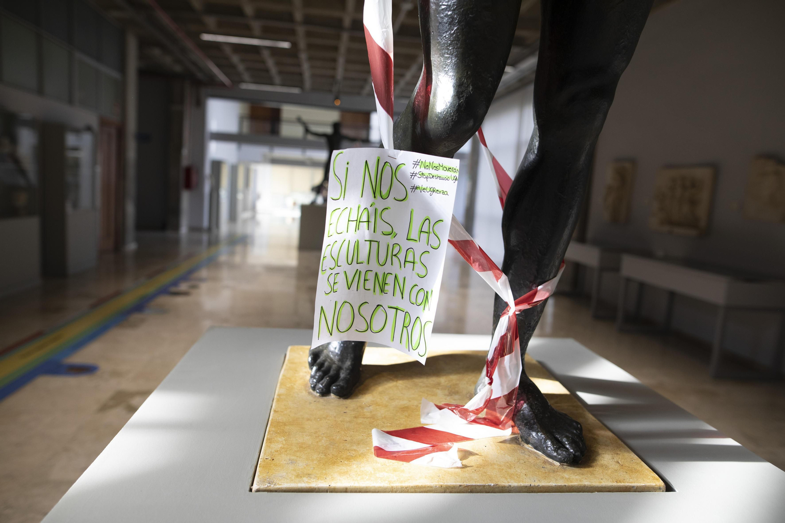 Cartel de protesta en una de las esculturas de la Facultad.