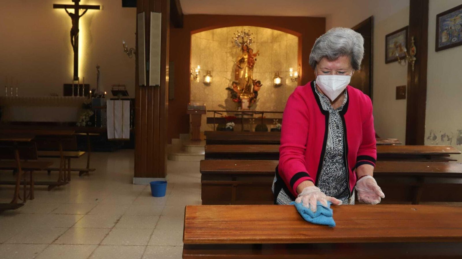 Una mujer desinfecta los bancos de la parroquia del Carmen, en Algeciras.