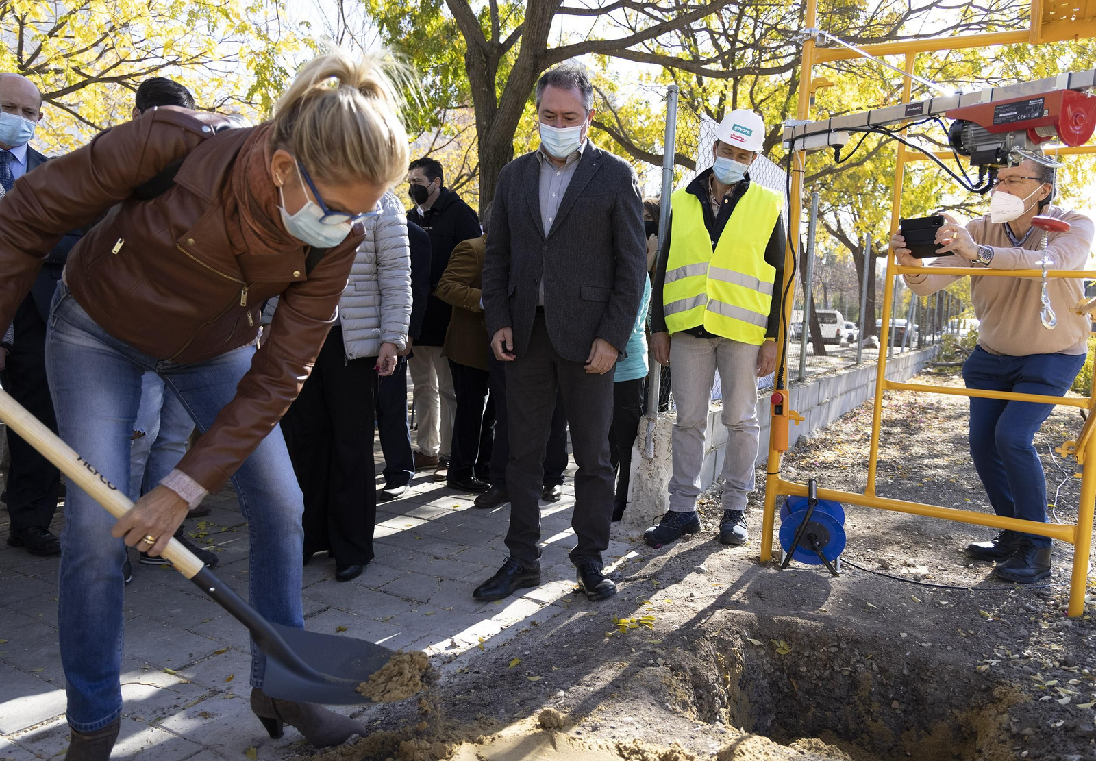 Espadas observa como una vecina de Sevilla Este coloca la primera piedra del nuevo centro cívico.