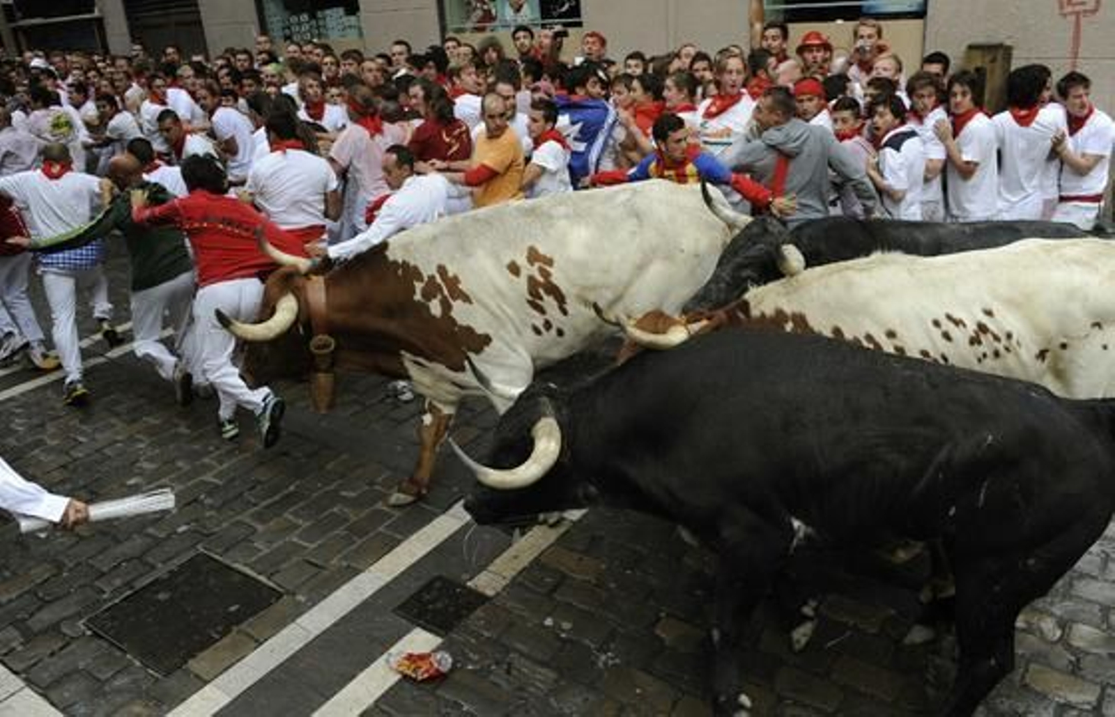 El primer encierro de 2012 finaliza con una cornada en el primer tramo y la entrada en la plaza de un toro con un mozo en una de sus astas.

Foto: EFE / Reuters