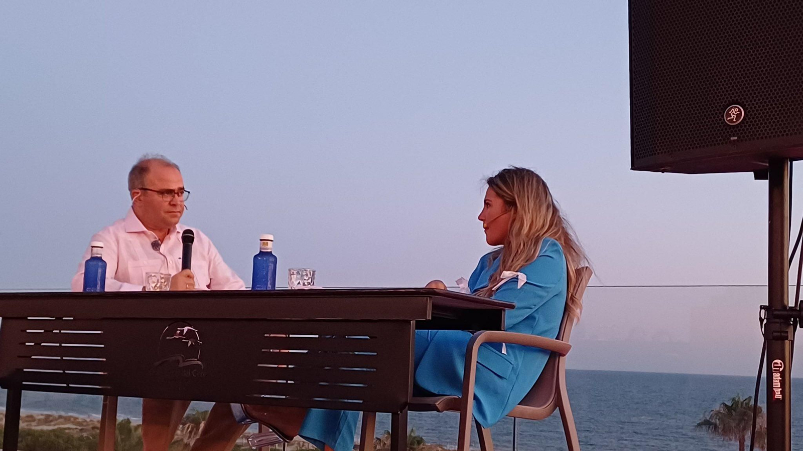 Laura Gallego en la charla con Navarro Antolín con el mar de Matalascañas de fondo.